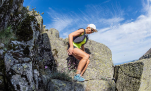 Woman hiking rocky terrain wearing athletic gear—no knee brace shown.